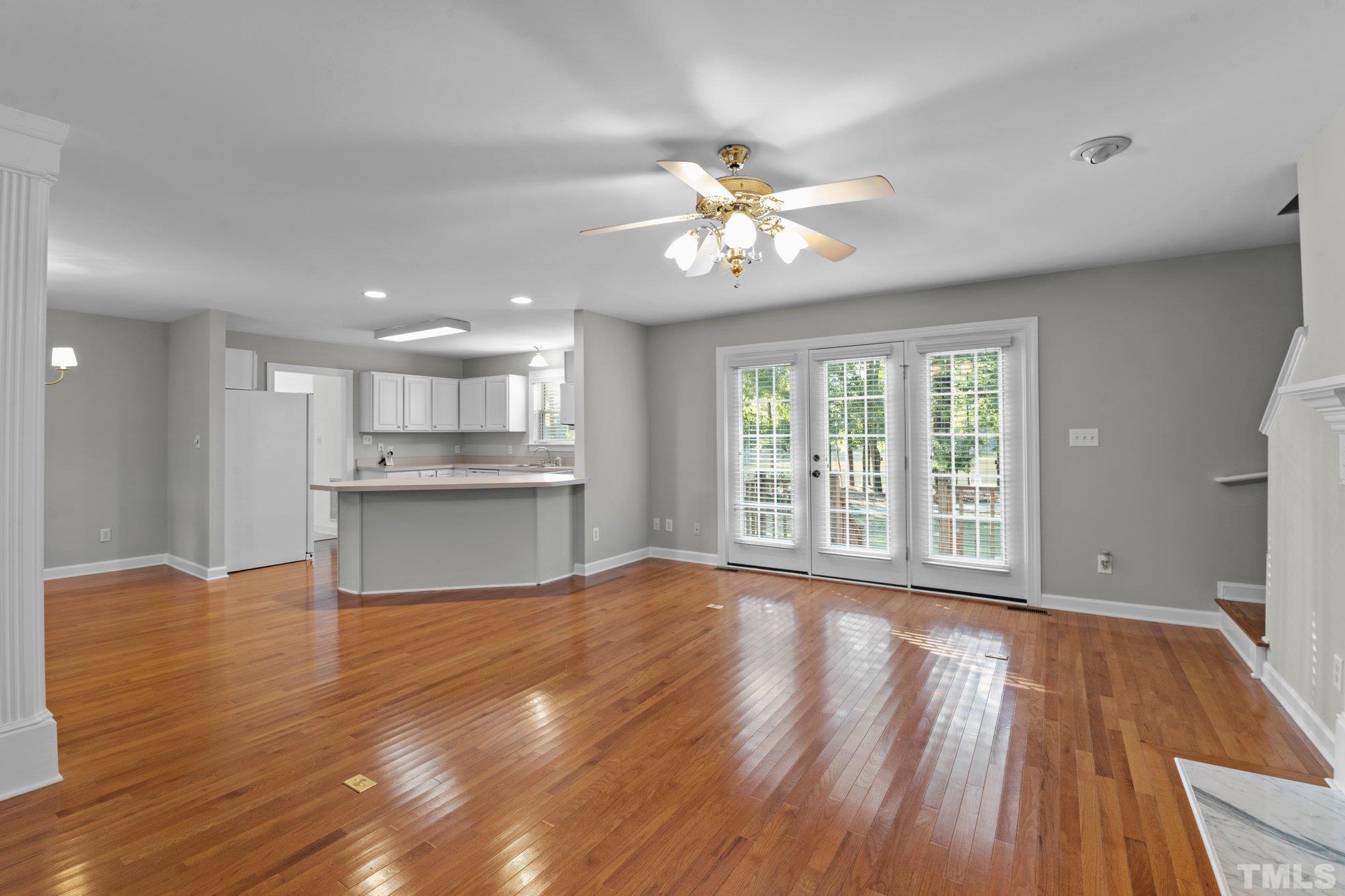 8025 Lockleair Road Zebulon, NC 27597 - Photo 12 of 30 First view of open living plan featuring hardwood floors, fresh new paint, fireplace, dining with half wall for a minor separation, and kitchen bar for dining and/or serving.