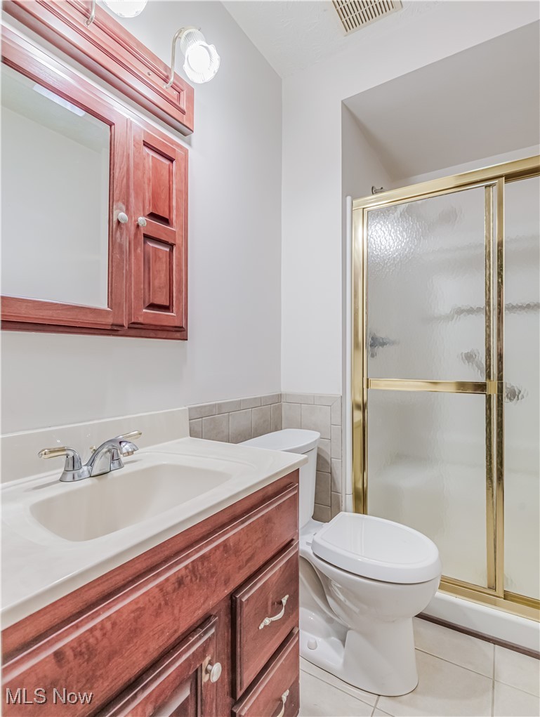 3087 Baughman Road Clinton, OH 44216 - Photo 16 of 24 Bathroom with tile patterned floors, vanity, toilet, and a shower with shower door