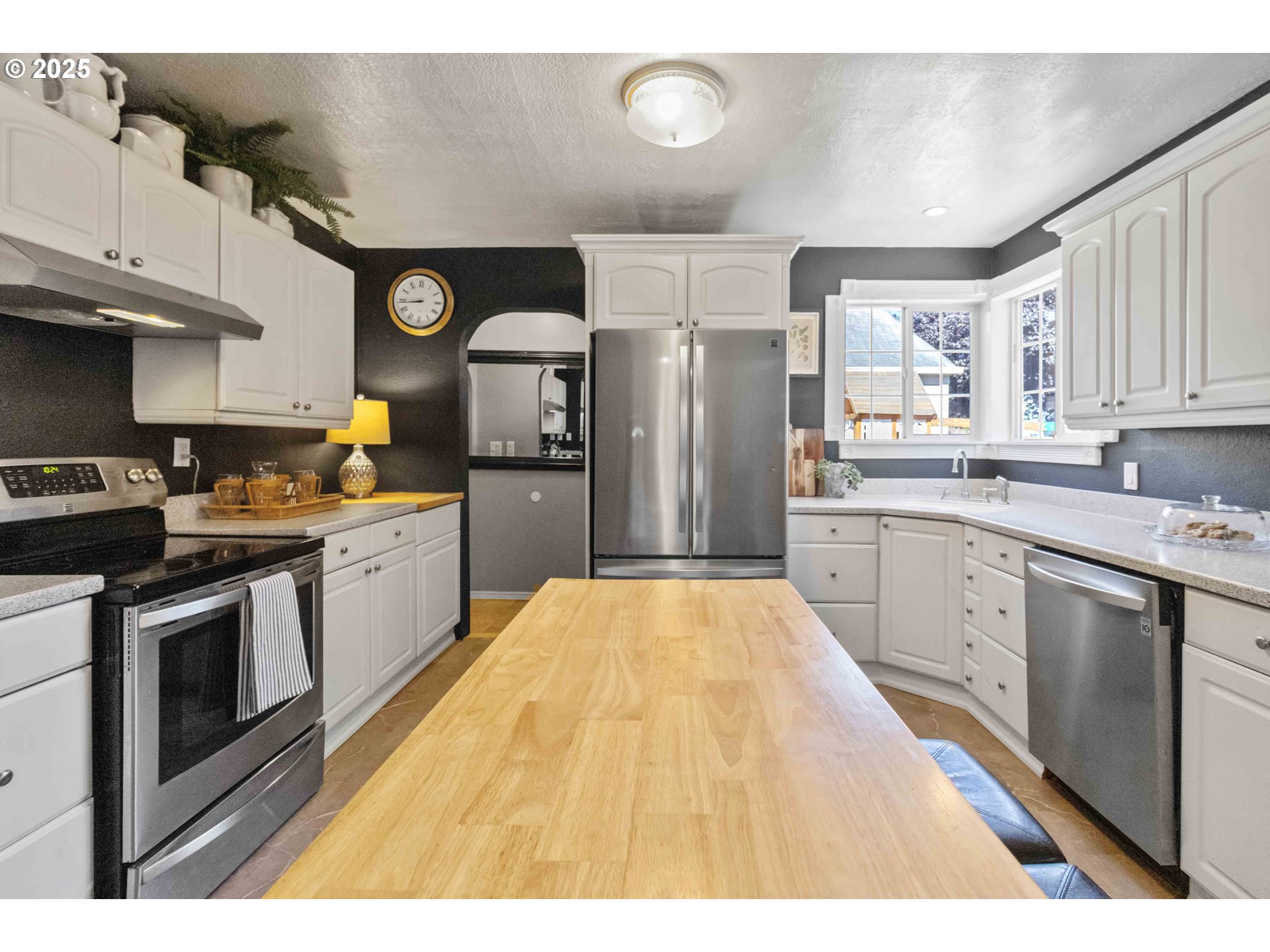 567 20th Avenue Longview, WA 98632 - Photo 11 of 41 a kitchen with stainless steel appliances kitchen island granite countertop a refrigerator a sink dishwasher and white cabinets with wooden floor