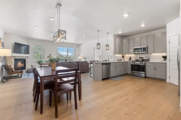 a view of kitchen with kitchen island a stove a table and chairs in it