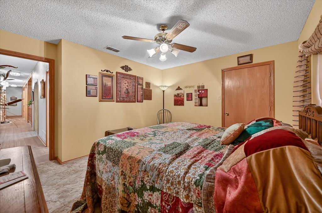1605 Heather Court Cleburne, TX 76033 - Photo 18 of 33 a bedroom with a bed and a chandelier