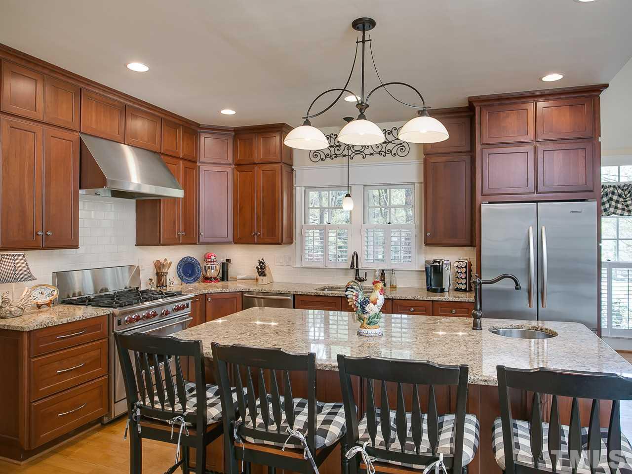 10300 Grafton Road Raleigh, NC 27615 - Photo 8 of 30 a kitchen with a dining table chairs sink and cabinets