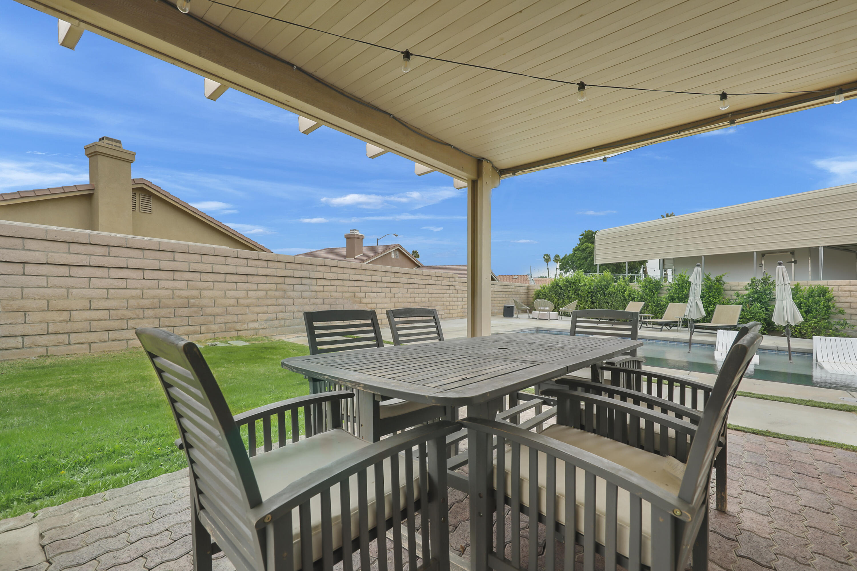 80490 Paseo Tesoro Indio, CA 92201 - Photo 19 of 28 a view of a patio with table and chairs with wooden floor and fence