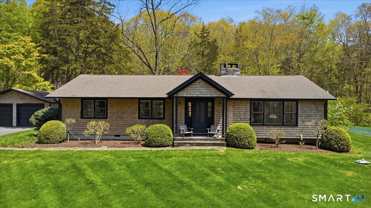 246 North Street Roxbury, CT 06783 - Photo 1 of 22 a front view of a house with garden and trees