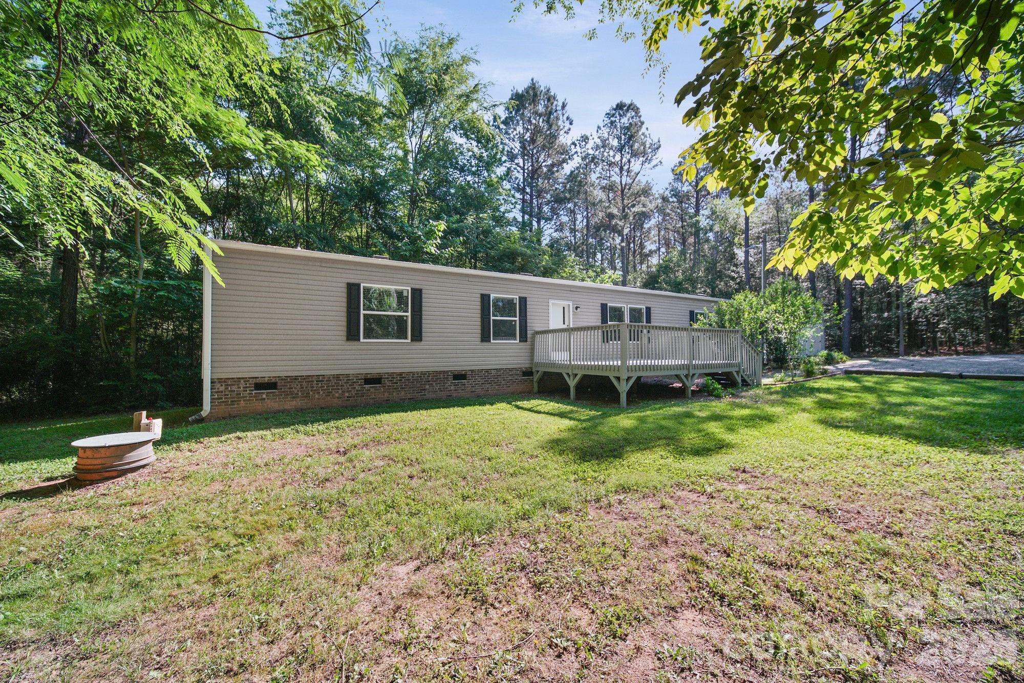 4507 White Store Road Wingate, NC 28174 - Photo 3 of 29 a backyard of a house with a garden and deck