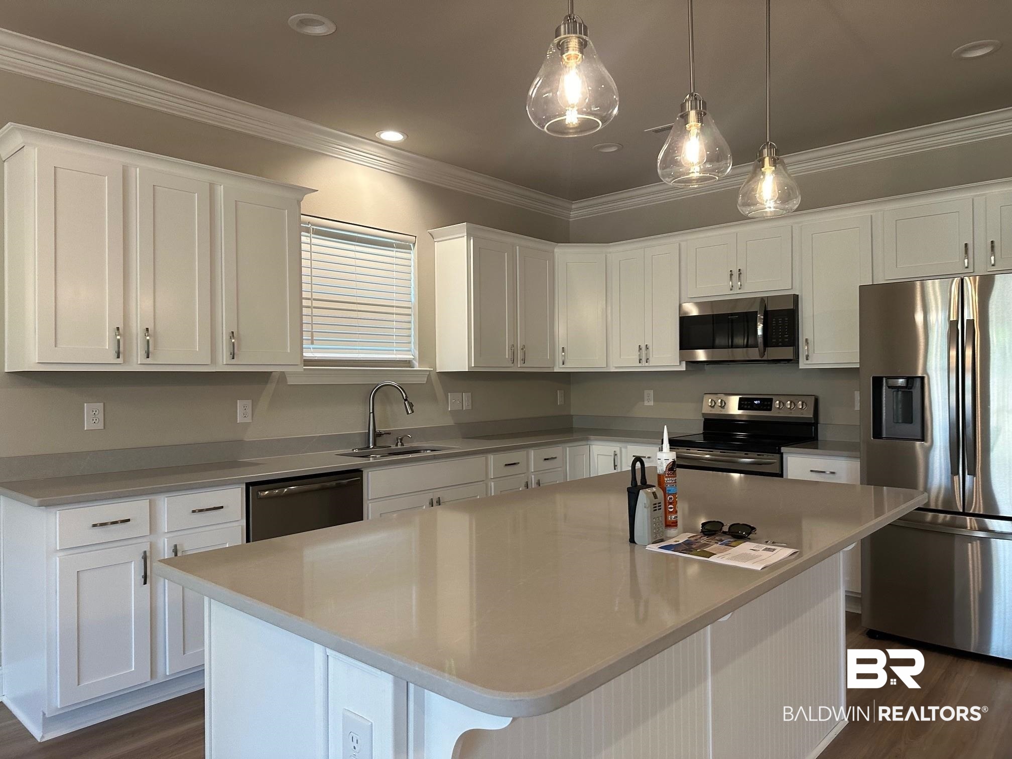 1009 Ruisseau Drive Foley, AL 36535 - Photo 26 of 55 Kitchen with appliances with stainless steel finishes, sink, a kitchen island, and white cabinets
