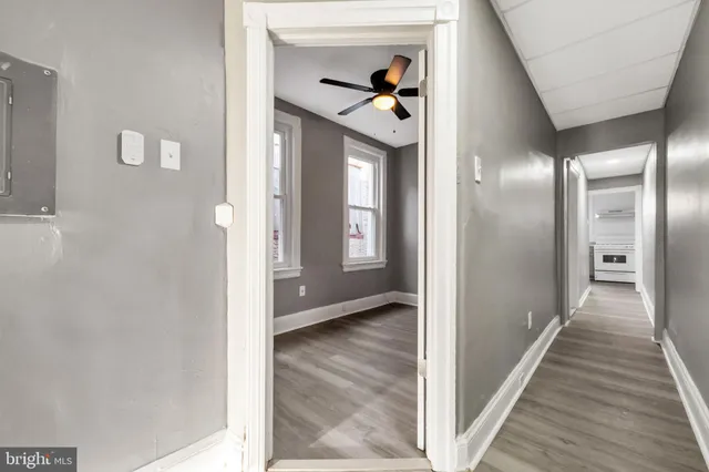 a view of a hallway with wooden floor and a living room