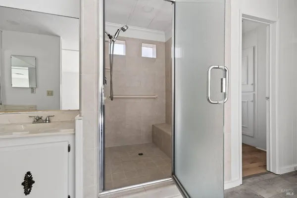a bathroom with a shower sink and mirror