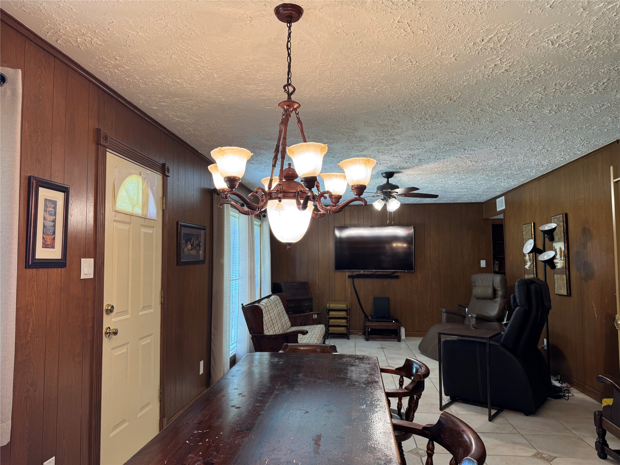 203 East Thornton Road Houston, TX 77022 - Photo 6 of 18 Warm and inviting living space features rich wood-paneled walls, a textured ceiling, and a comfortable den area perfect for relaxing or entertaining.