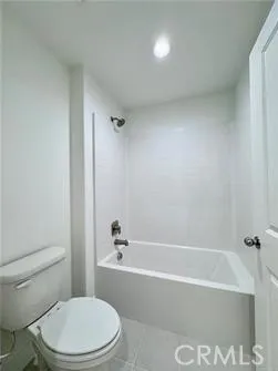 a white toilet and tub sitting next to a bathroom sink