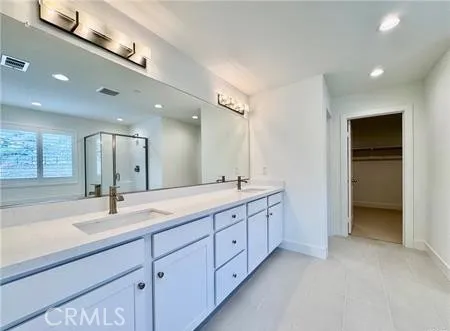 a bathroom with double sink and a mirror