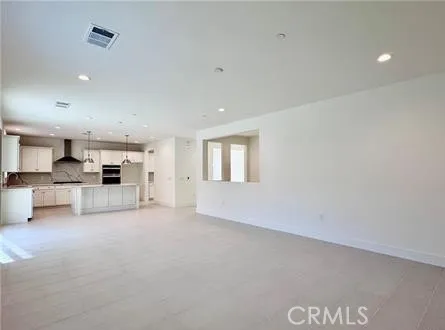 an empty room with furniture and a kitchen