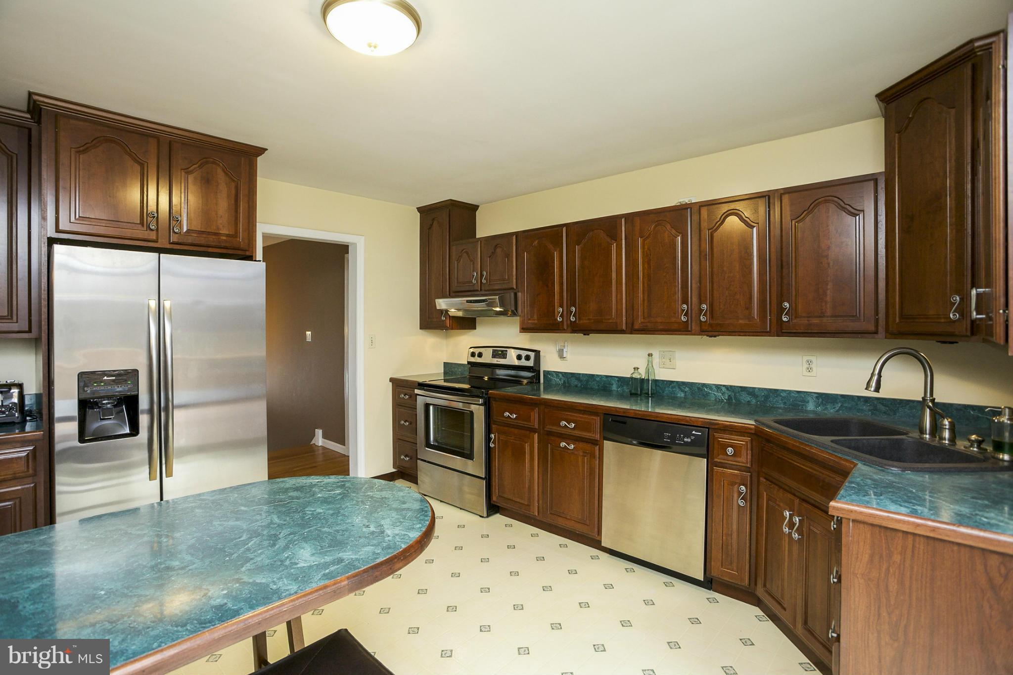 1712 Parkvue Road Fallston, MD 21047 - Photo 8 of 29 a kitchen with stainless steel appliances granite countertop a refrigerator a stove and a sink with wooden cabinets