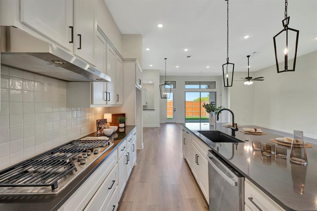 2901 Long Trail Mansfield, TX 76063 - Photo 22 of 28 a kitchen with stainless steel appliances granite countertop a sink a stove and a wooden floors