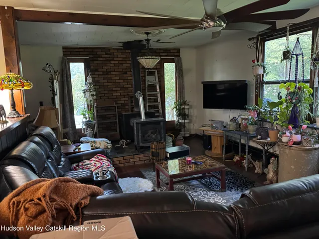 a living room with furniture a large window and a flat screen tv