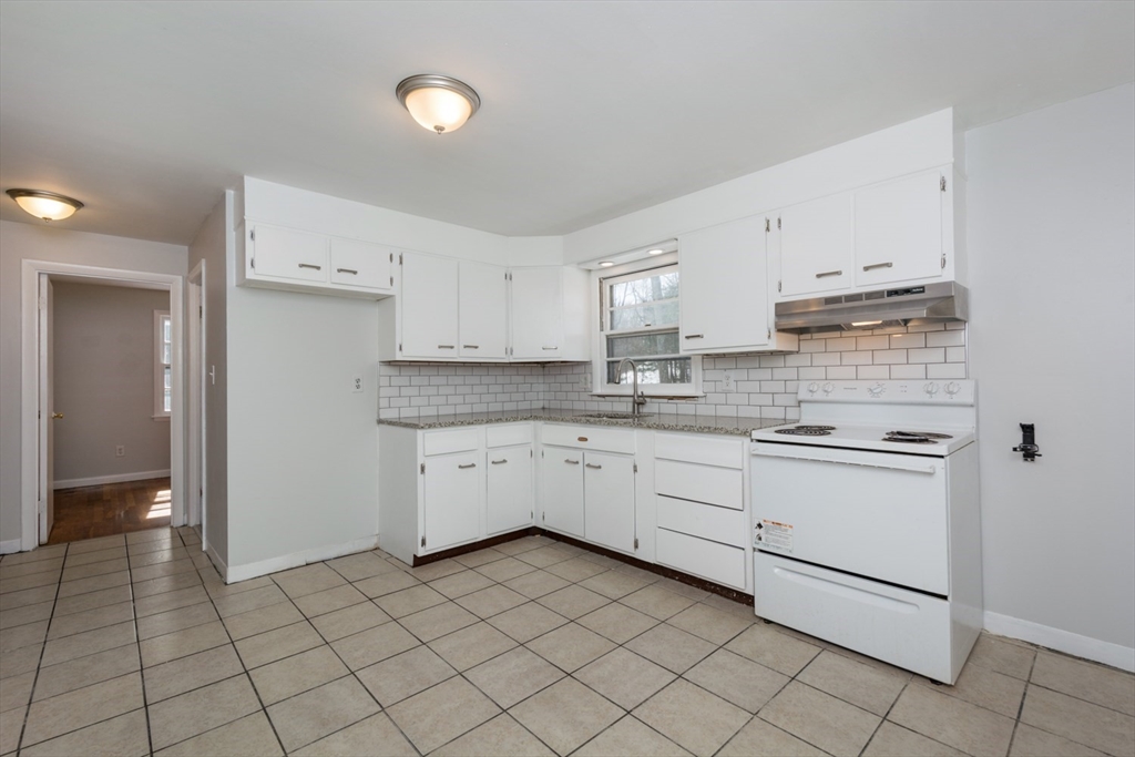 22 Southwest Cutoff, Unit C Northborough, MA 01532 - Photo 4 of 14 a kitchen with granite countertop white cabinets and white appliances