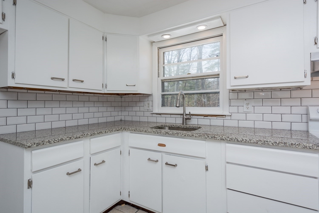 22 Southwest Cutoff, Unit C Northborough, MA 01532 - Photo 7 of 14 a kitchen with granite countertop white cabinets and a window