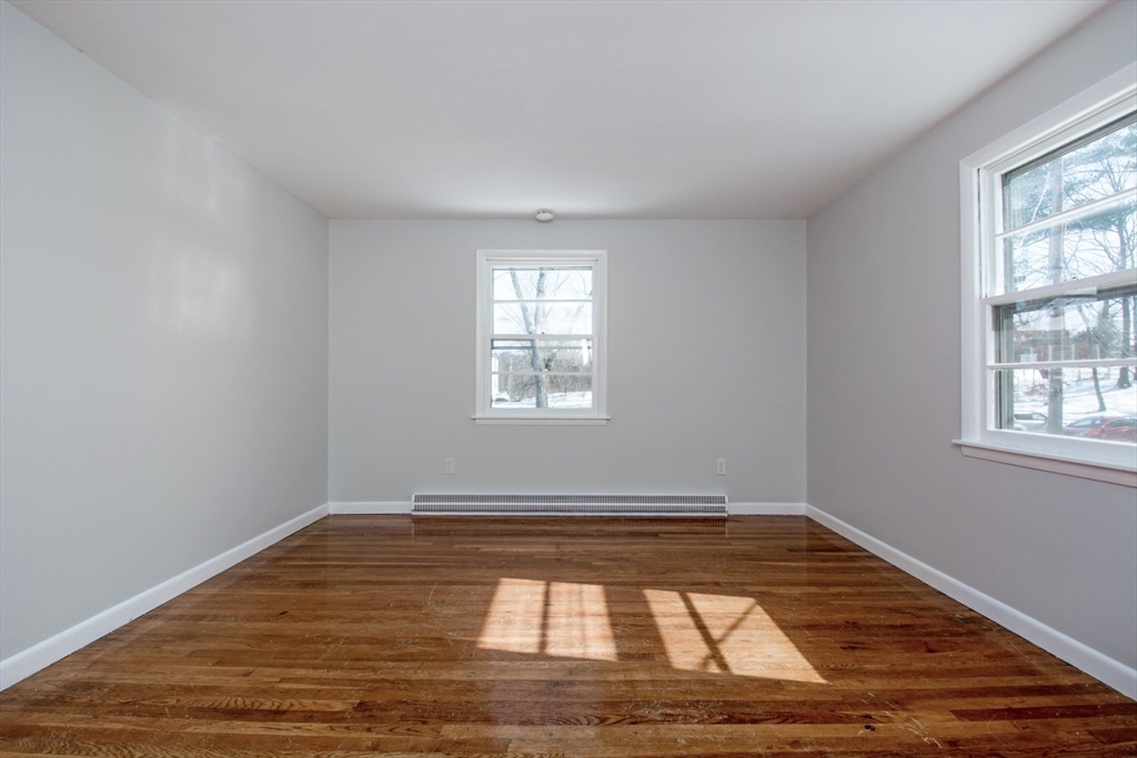 22 Southwest Cutoff, Unit C Northborough, MA 01532 - Photo 10 of 14 a view of empty room with wooden floor and window