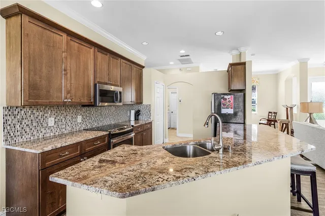a kitchen with stainless steel appliances granite countertop a sink stove and microwave
