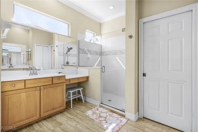 a bathroom with a double vanity sink mirror and shower