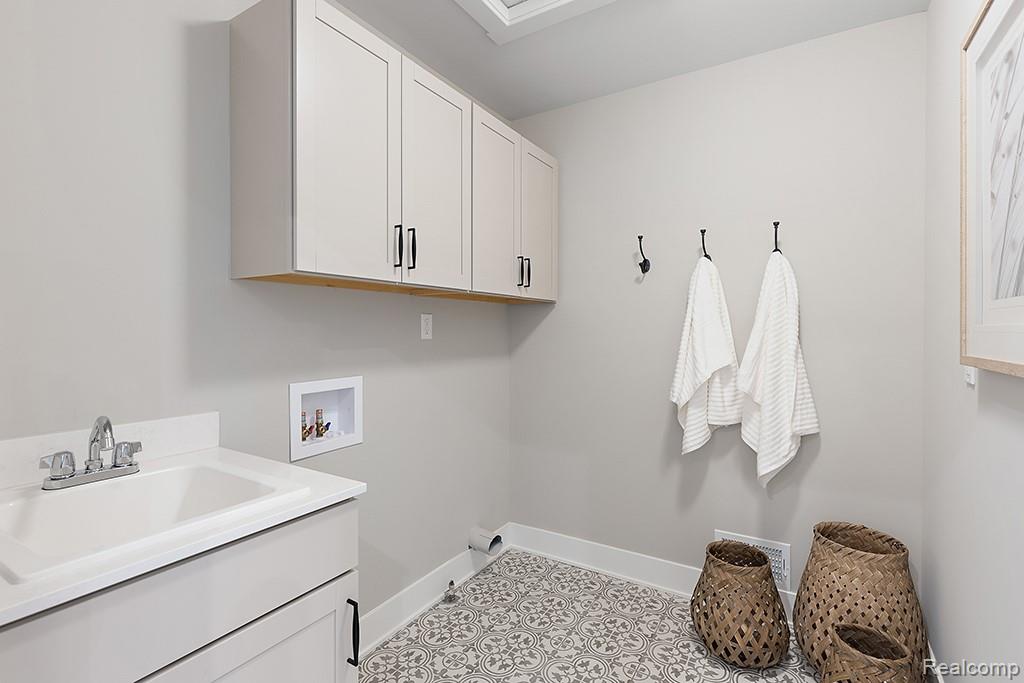 6107 Pollak Road Ypsilanti, MI 48197 - Photo 50 of 51 Laundry area featuring hookup for a washing machine, cabinet space, and light tile patterned floors