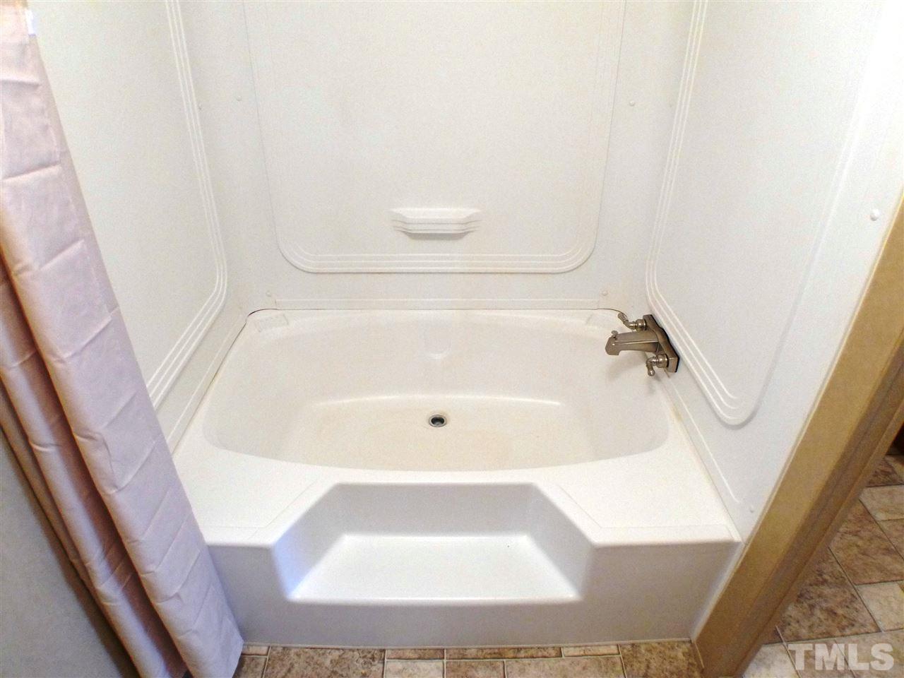 7515 Bill Love Road Willow Spring, NC 27592 - Photo 11 of 20 a bathroom with a white bath tub