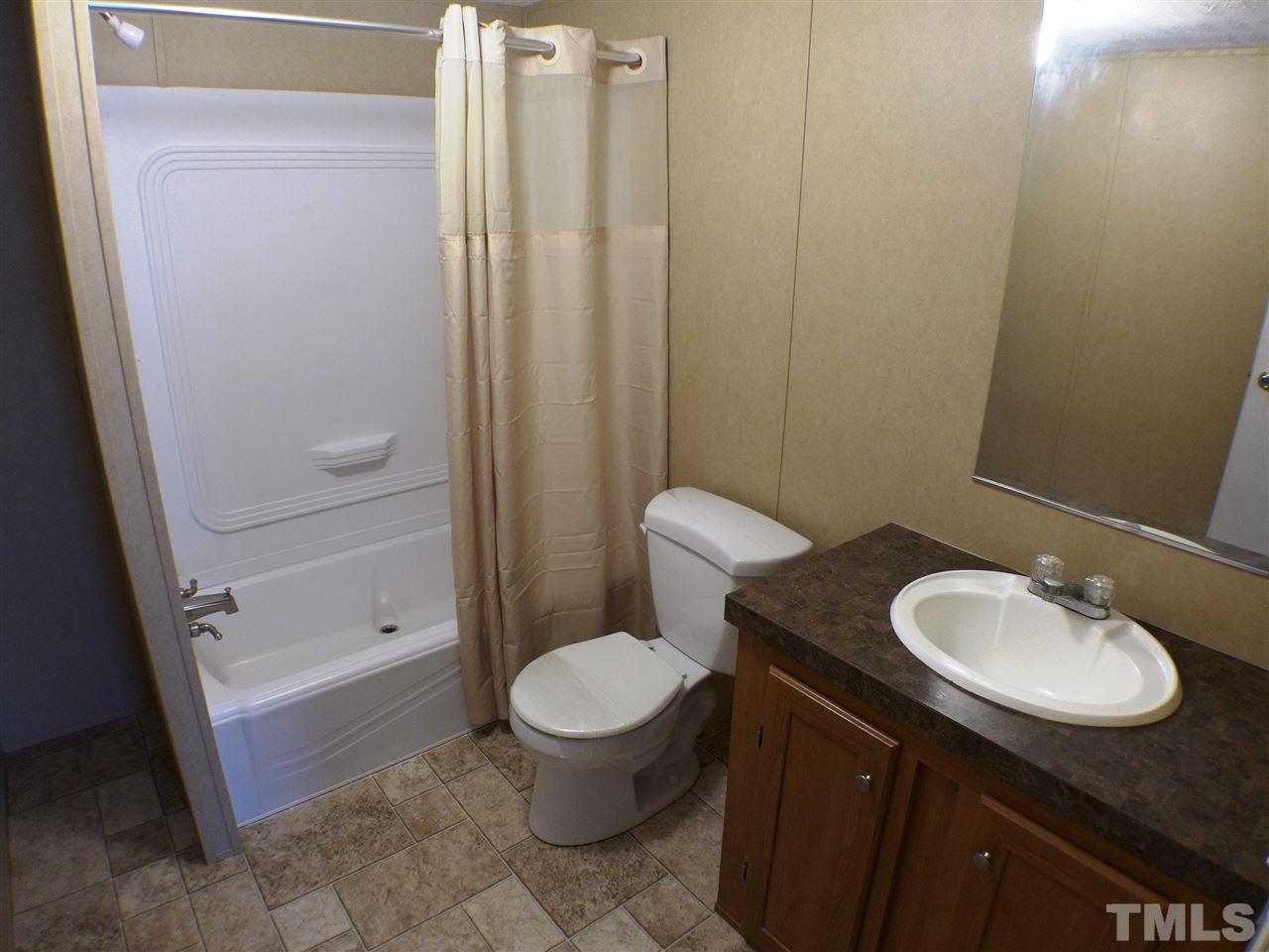 7515 Bill Love Road Willow Spring, NC 27592 - Photo 13 of 20 a bathroom with a granite countertop sink toilet and shower