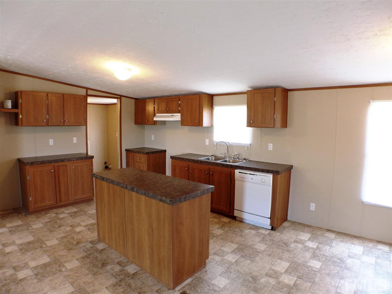 7515 Bill Love Road Willow Spring, NC 27592 - Photo 3 of 20 a kitchen with granite countertop a sink stove and cabinets