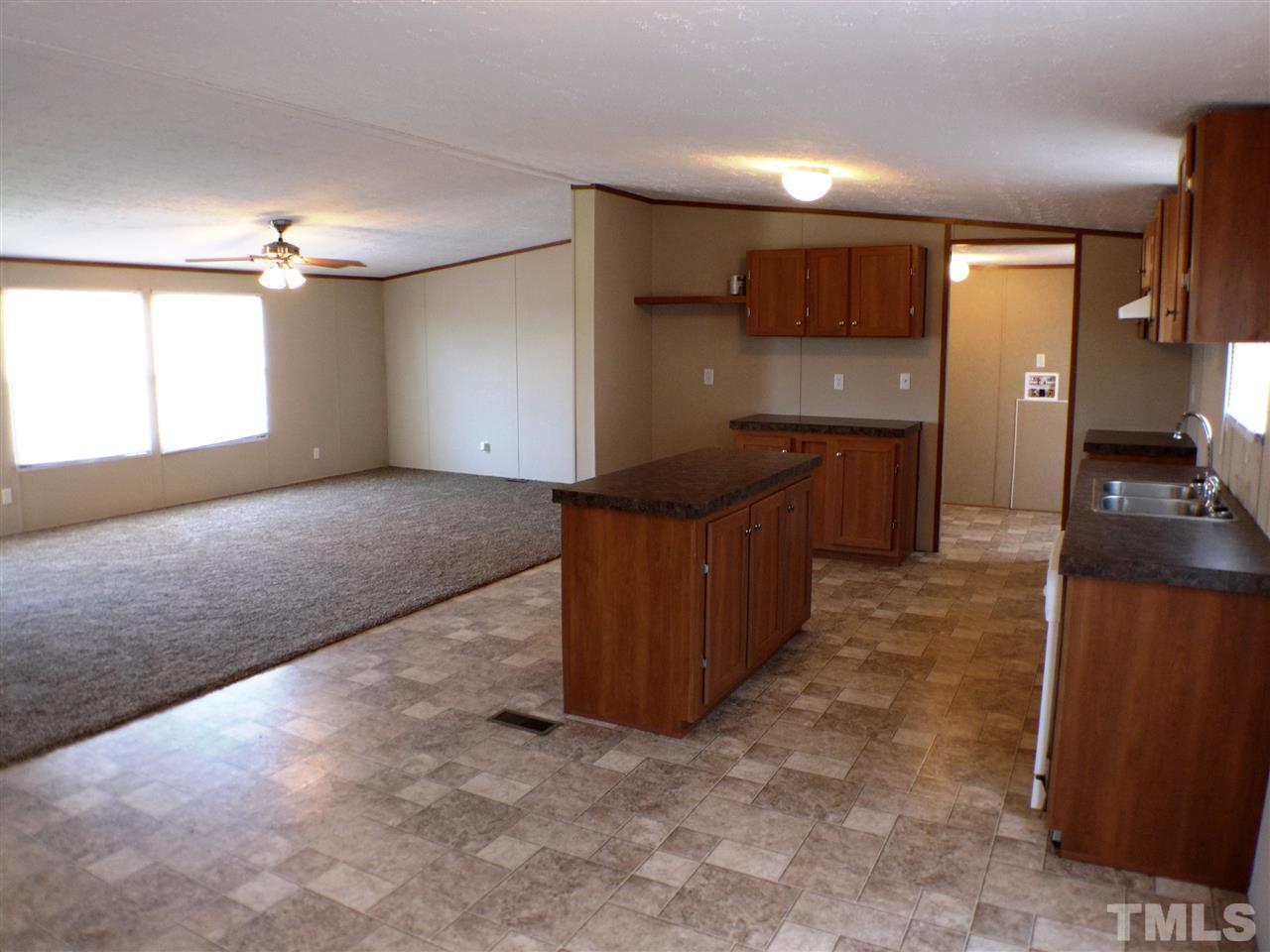 7515 Bill Love Road Willow Spring, NC 27592 - Photo 4 of 20 a open kitchen with kitchen island granite countertop a refrigerator and a sink
