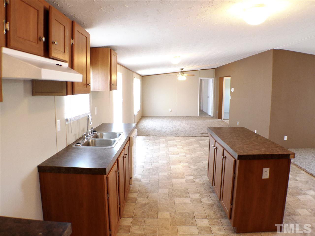 7515 Bill Love Road Willow Spring, NC 27592 - Photo 5 of 20 a kitchen with kitchen island granite countertop a sink stove and cabinets
