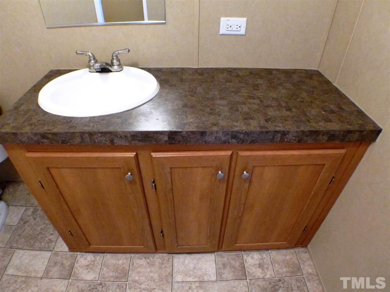 7515 Bill Love Road Willow Spring, NC 27592 - Photo 10 of 20 a bathroom with a sink and a mirror