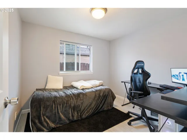 a bedroom with a bed window and a desk