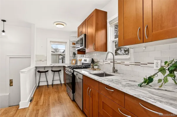 a kitchen with stainless steel appliances granite countertop sink stove top oven and cabinets