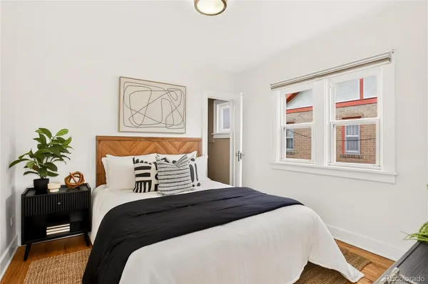 a bedroom with a large bed and a potted plant