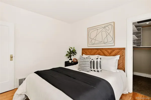 a bedroom with a bed and painting on the wall