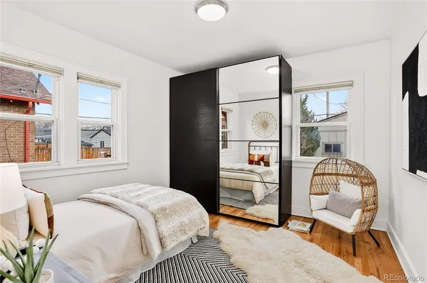a bedroom with a bed chair and a large window