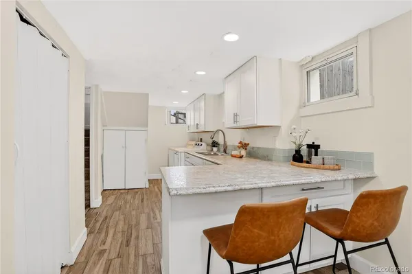 a kitchen with stainless steel appliances granite countertop a sink a stove a refrigerator a microwave with a dining table and chairs