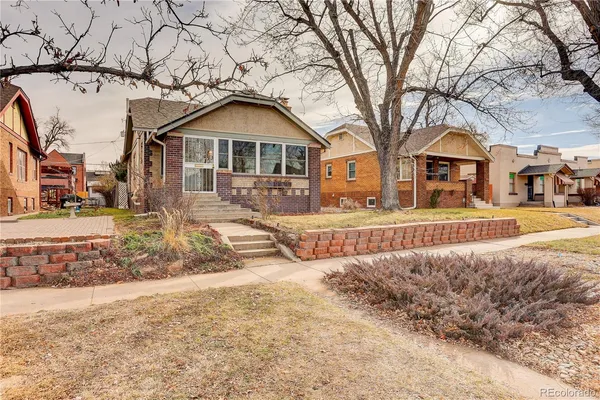 a front view of a house with a yard covered in snow