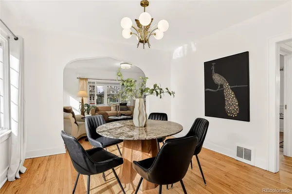 a dining room with furniture a potted plant and a chandelier