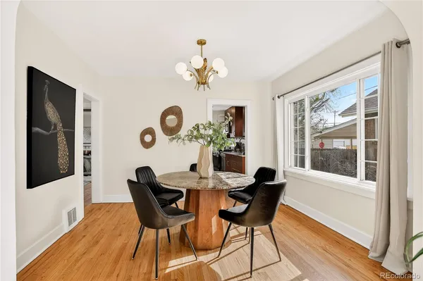 a dining room with furniture a potted plant and wooden floor