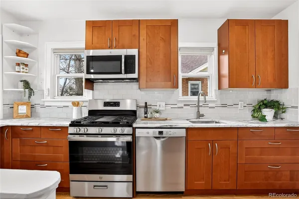 a kitchen with stainless steel appliances a stove a sink and a microwave