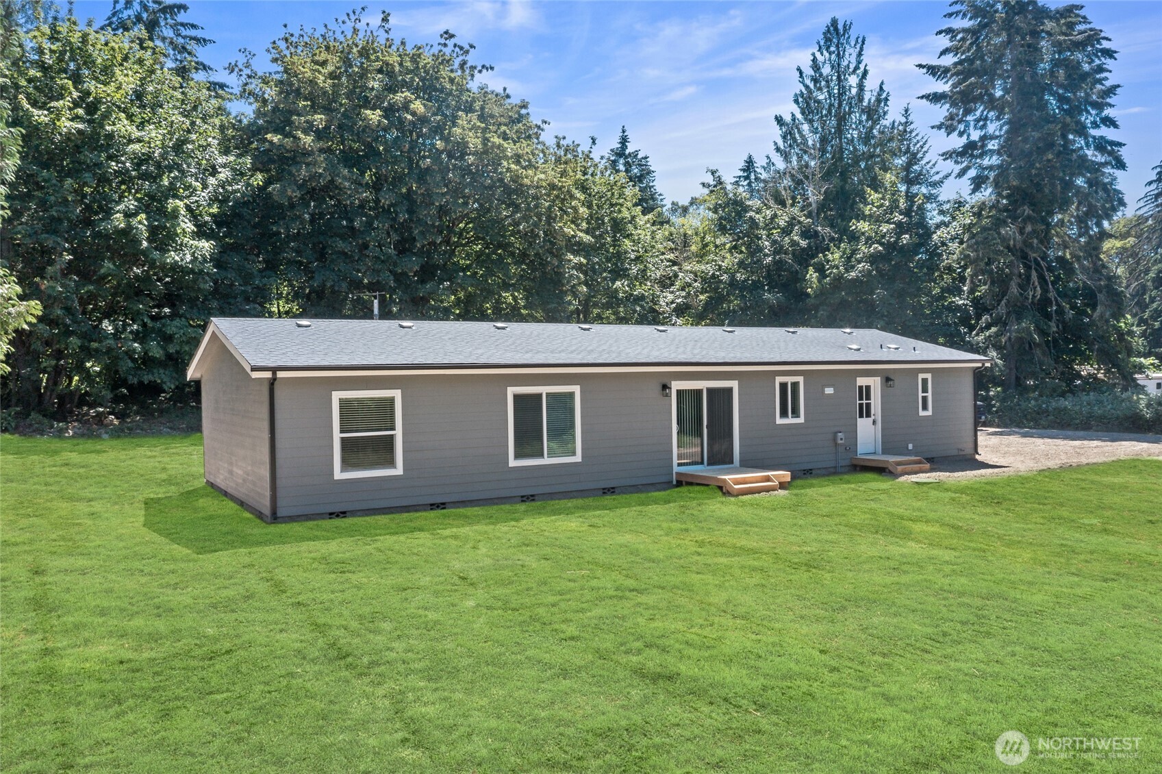 17217 80th Street Southwest Longbranch, WA 98351 - Photo 36 of 39 a house that is sitting in the grass with large trees and wooden fence
