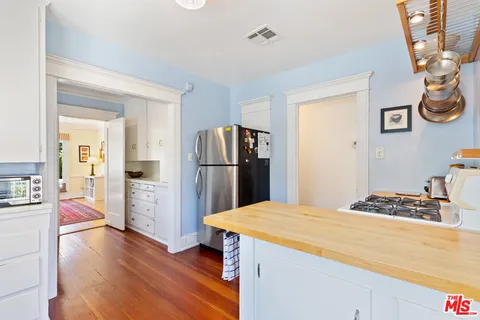 a kitchen with stainless steel appliances kitchen island granite countertop a refrigerator and a stove top oven