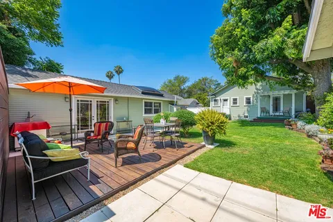 a view of a house with backyard sitting area and garden