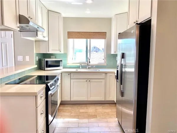 a kitchen with stainless steel appliances a refrigerator sink and cabinets