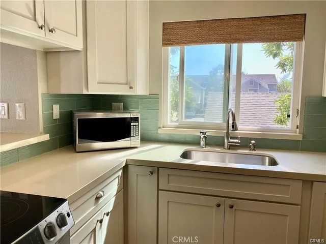 a kitchen with stainless steel appliances granite countertop a sink and a microwave