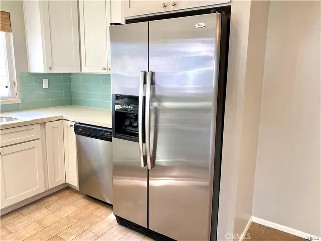 a kitchen with a refrigerator a sink and cabinets