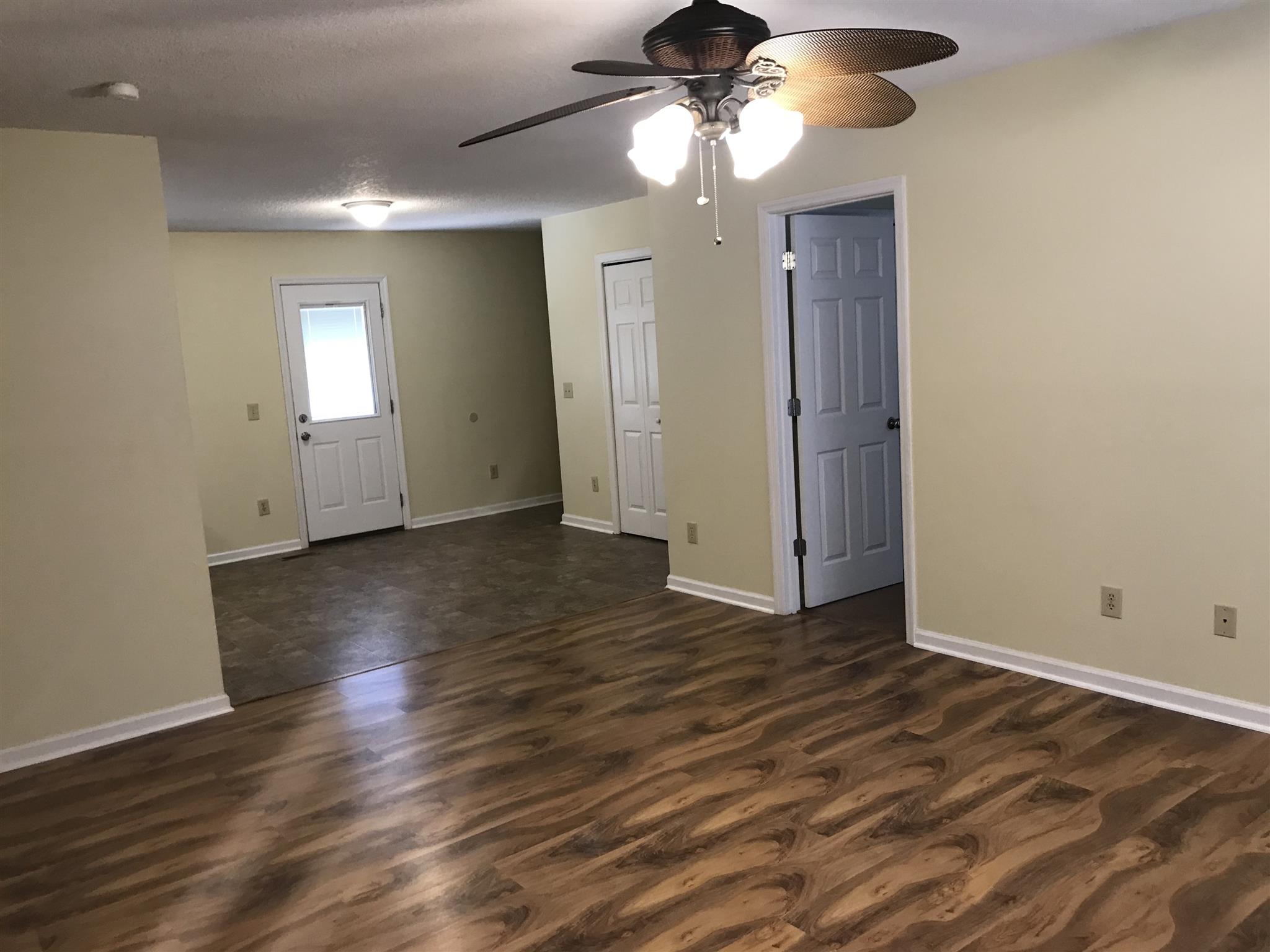 957 Shelly Road Decherd, TN 37324 - Photo 5 of 16 an empty room with wooden floor chandelier fan and closet area