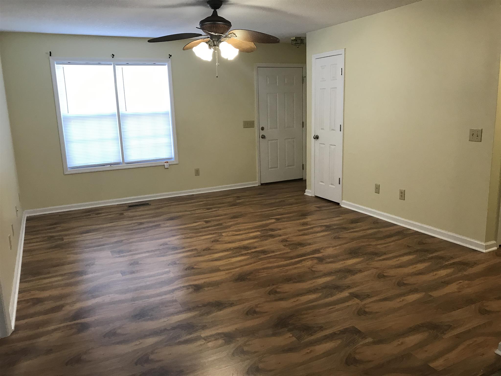 957 Shelly Road Decherd, TN 37324 - Photo 6 of 16 an empty room with wooden floor chandelier fan and windows