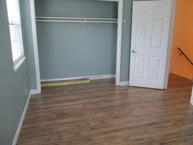 a view of room with window and wooden floor